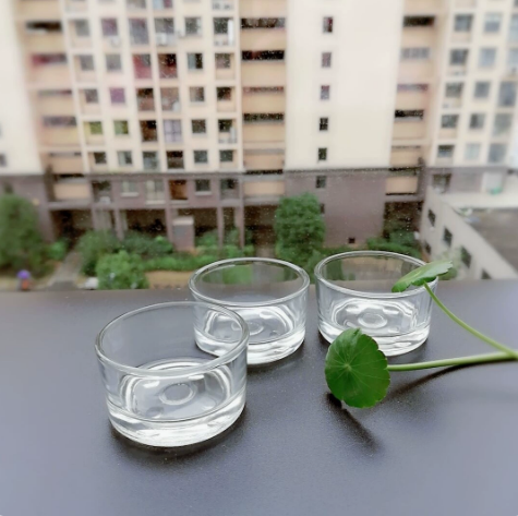 three small clear glass candle bowls viewed in natural light
